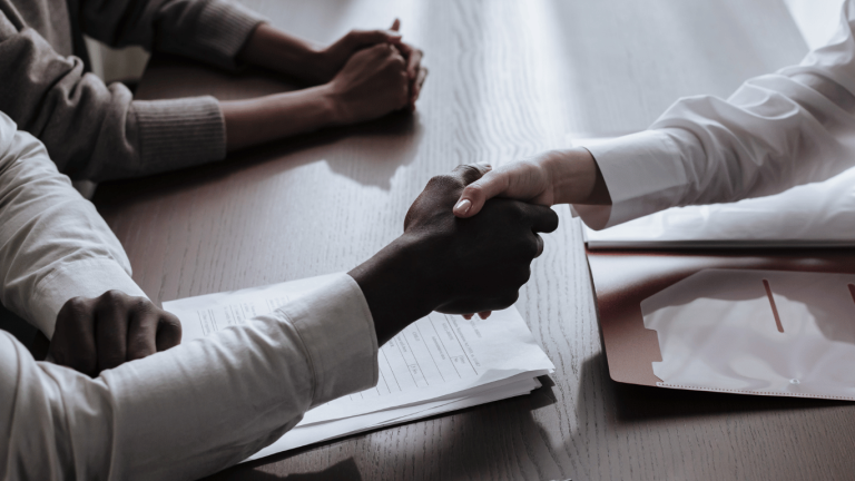 How to Negotiate a Better Salary After Receiving a Job Offer. Photo of hiring manager shaking hands with the job seeker who negotiated a higher salary.